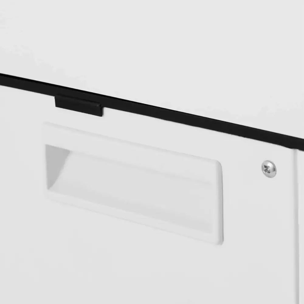 Elektrisk iskvern, detalj av hvitt metallhåndtak med innfelt grep, svart kant og synlig skrue til høyre.