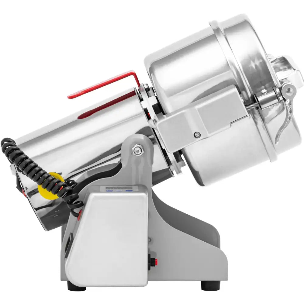 Elektrisk krydder- og nøttekvern i rustfritt stål, sidevisning med rød hendel og spiralformet ledning.