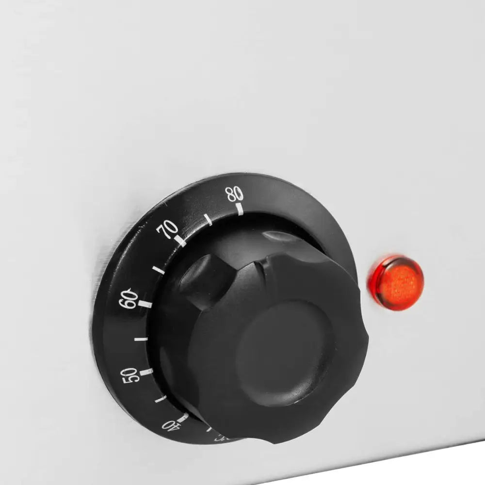 Elektrisk matbeholderoppvarmer, nærbilde av sort dreiebryter med temperatur og rød indikatorlampe.