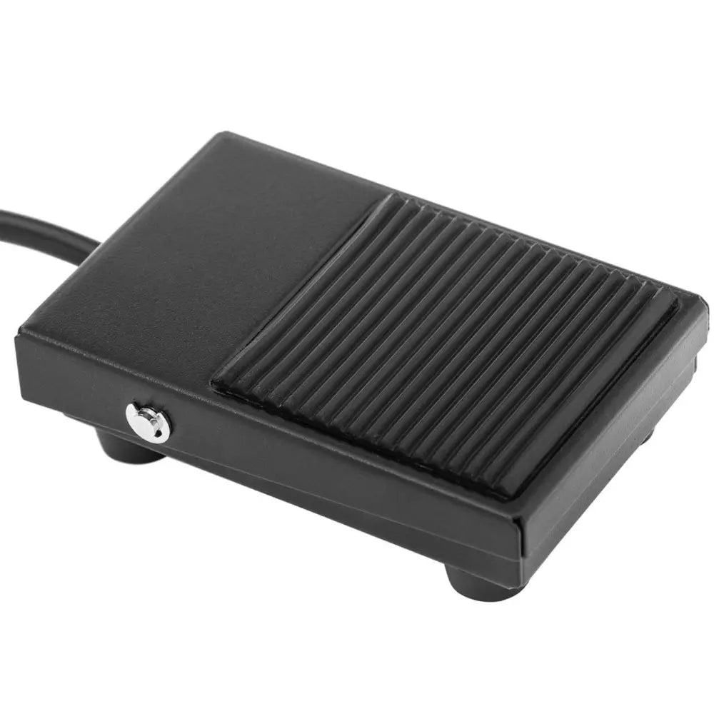 Elektrisk pølsefyller pedal, sort plast med riflet overflate, skrå vinkel, ledning synlig til venstre.