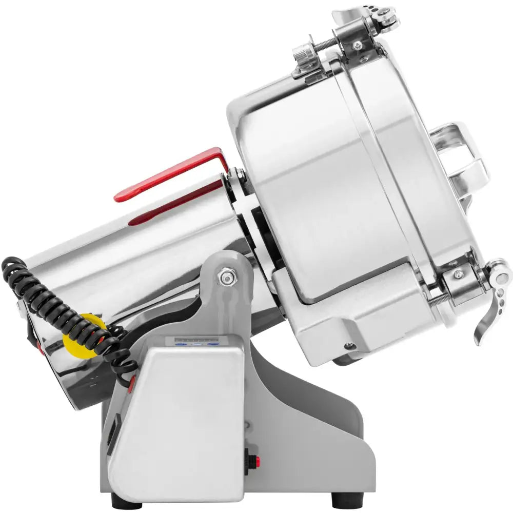 Elektrisk krydder- og urtemølle i rustfritt stål, sidevisning med rødt håndtak og spiralformet ledning bak.