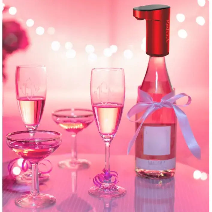 Elektrisk pumpe til drikkevarer, montert på rosa vinflaske med silkebånd, flankert av tre glass rosévin.