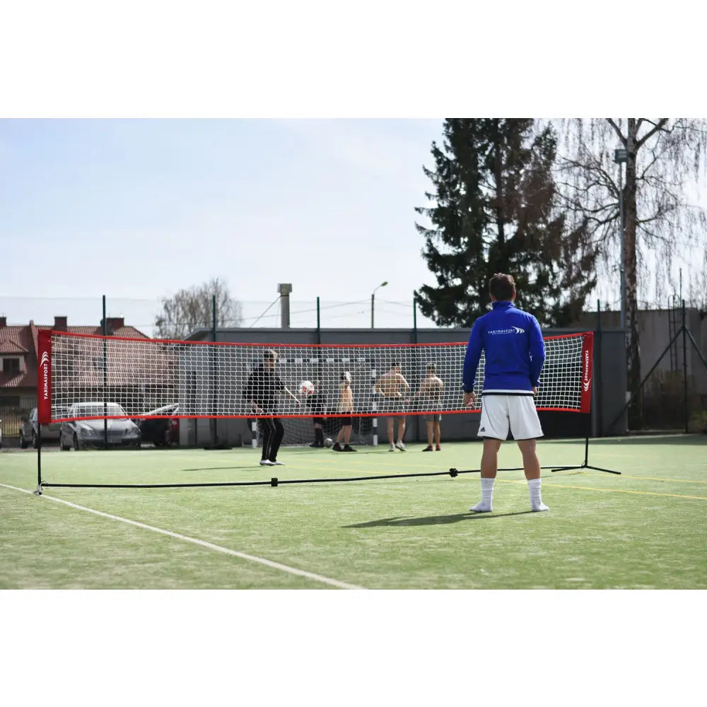 Elite Pro Indoor Volleyball Net Set med rød ramme og sort stativ, brukt under ballspill på utendørs bane.
