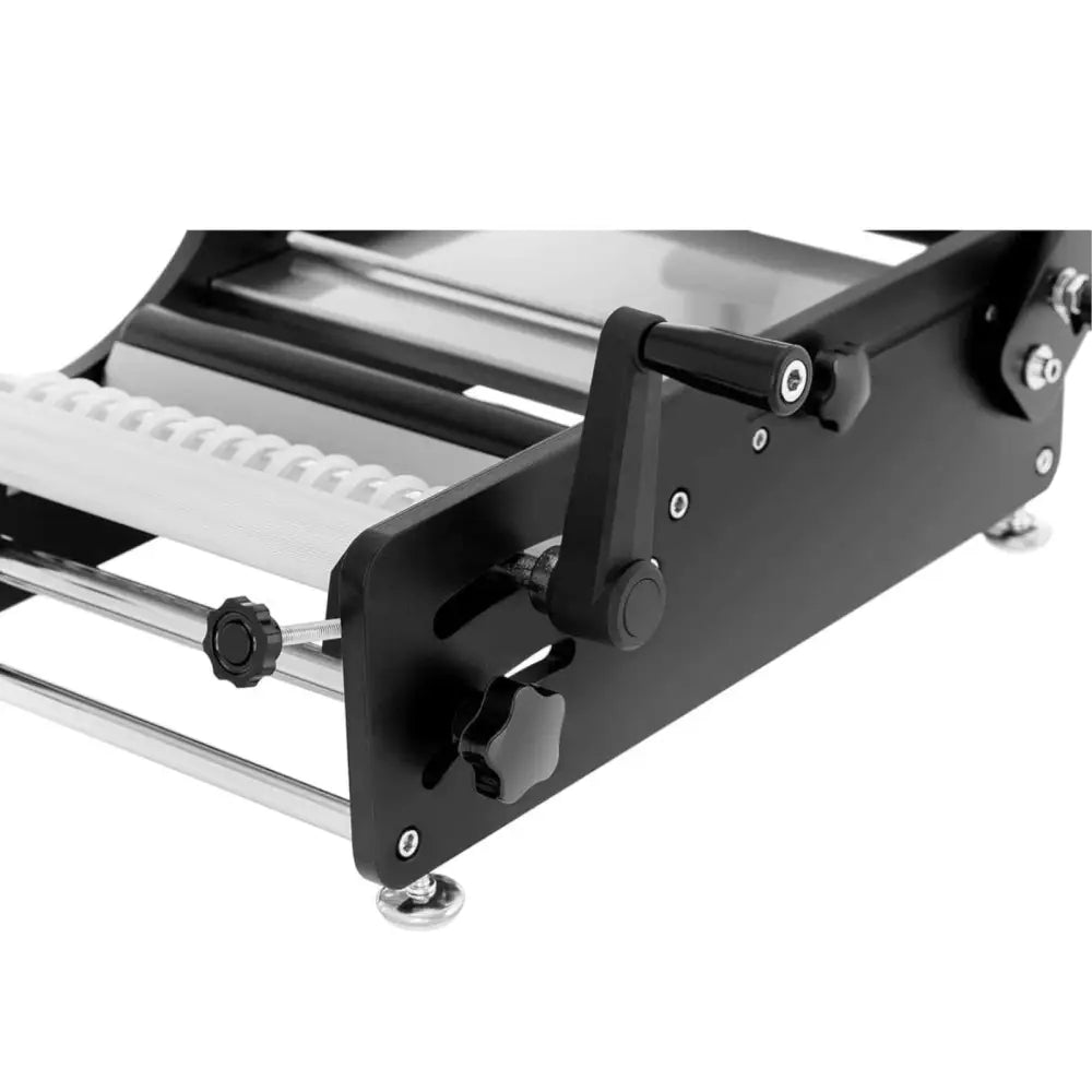 Etiketteringsmaskin for flasker, sidevisning av håndsveiv, justerbare knotter og hvite strukturert ruller.