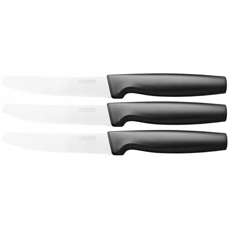 Fiskars tomatknivsett med tre kniver, sidevisning av taggete blader og svarte skaft mot hvit bakgrunn.