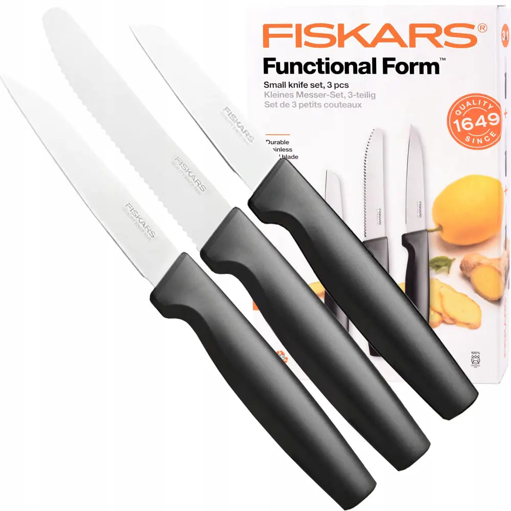Fiskars sett med tre små kjøkkenkniver, svarte håndtak og blanke klinger, foran produktesken.