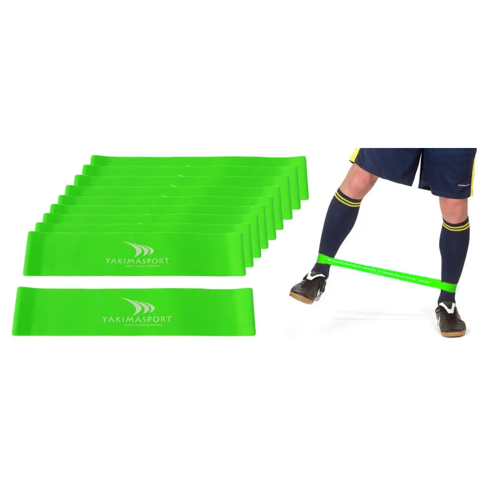 Fitnessgummi sett med 20 grønne treningsstrikker, stablet og demonstrert rundt ben på person i treningstøy.