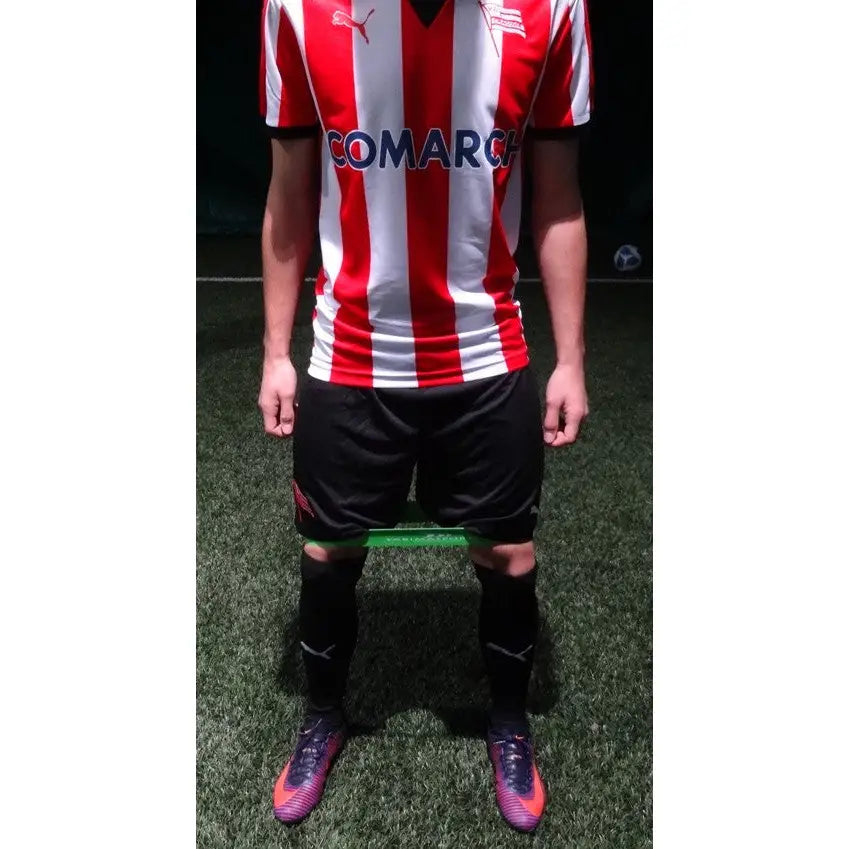 Fitnessgummi grønt bånd med høy motstand, brukt rundt lårene under trening på kunstgress.