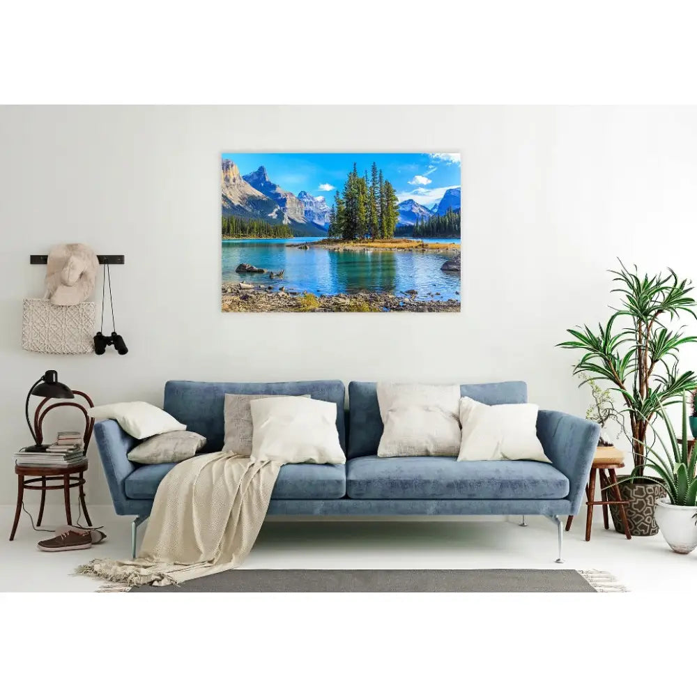 Fjell og innsjø lerretsbilde over blå sofa med lyse puter i lys stue, fokus på veggdekor.