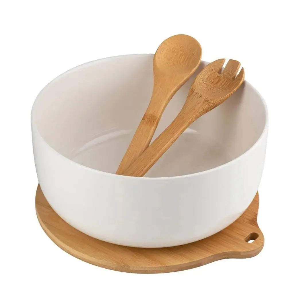 Florina Adria salatskål i hvit keramikk, sett ovenfra med bambusfot og lyst salatbestikk på kjøkkenbenk.