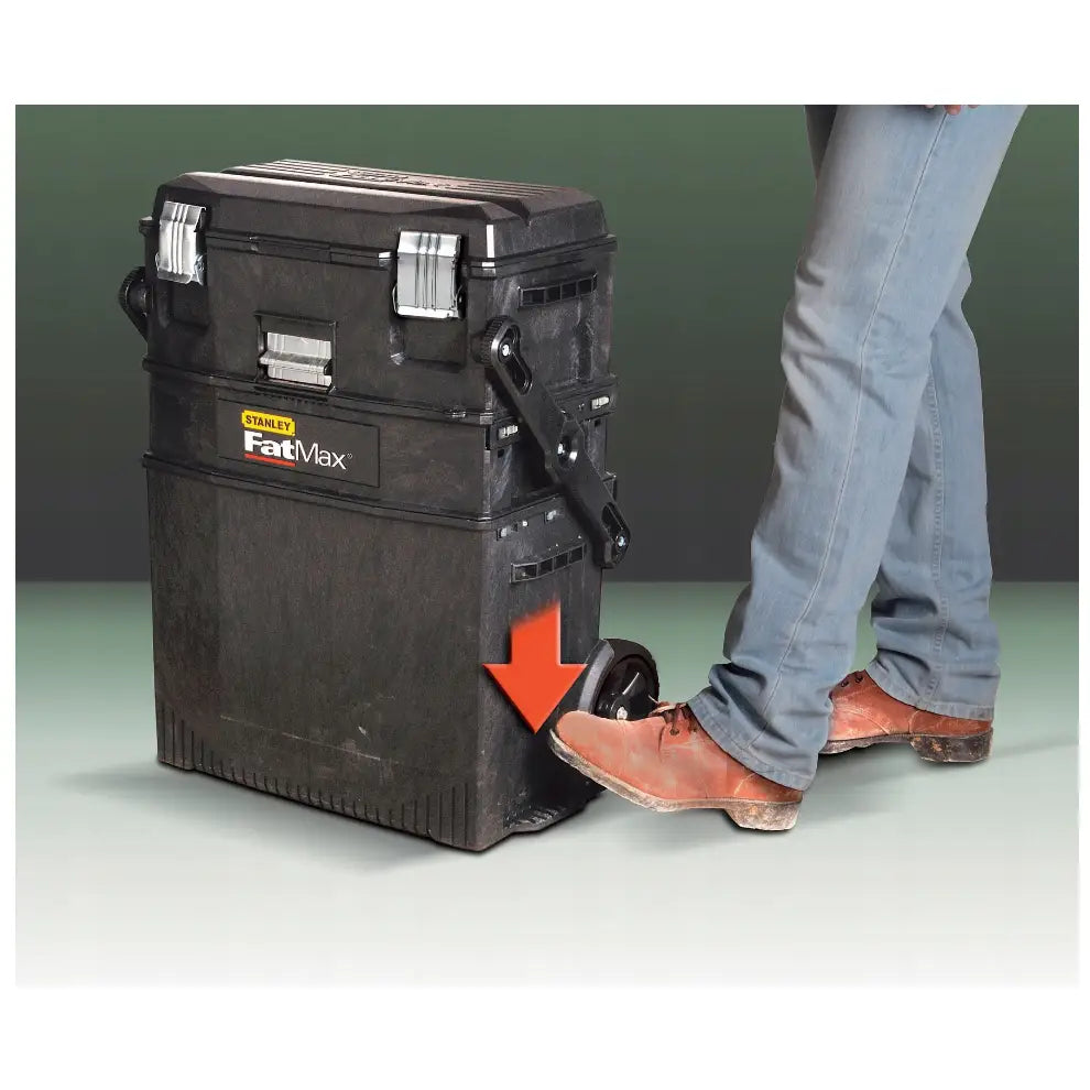 Flyttbar verkstedsvogn Fatmax, sort plastkasse med metallspenner, fot aktiverer hjulfunksjon med rød pil.