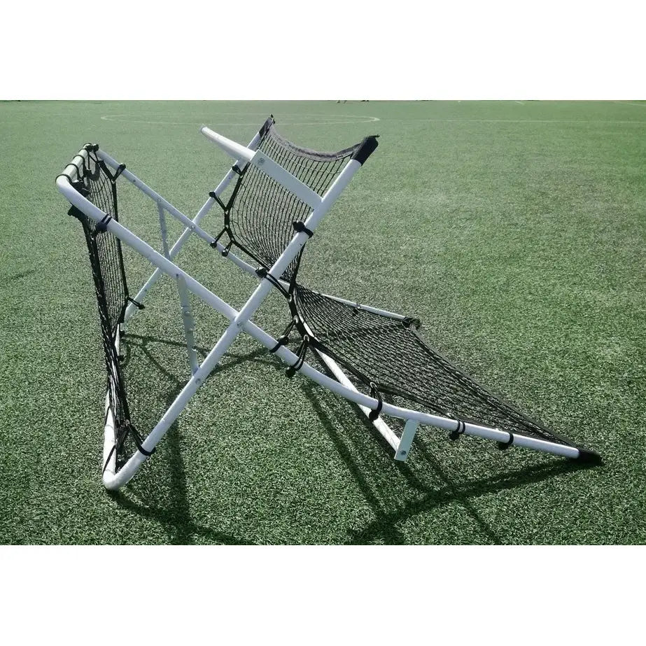 Fotball rebounder vegg, sidevisning av sammenleggbart nett med hvit ramme og skråstilte returflater på gress.