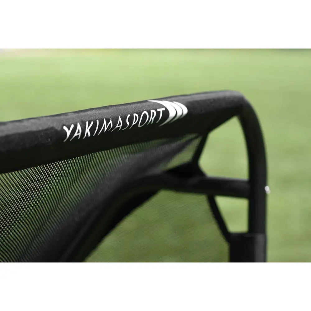 Fotballmål GIZA, detaljvisning av sort netting og ramme med YAKIMASPORT-logo mot grønn bakgrunn.