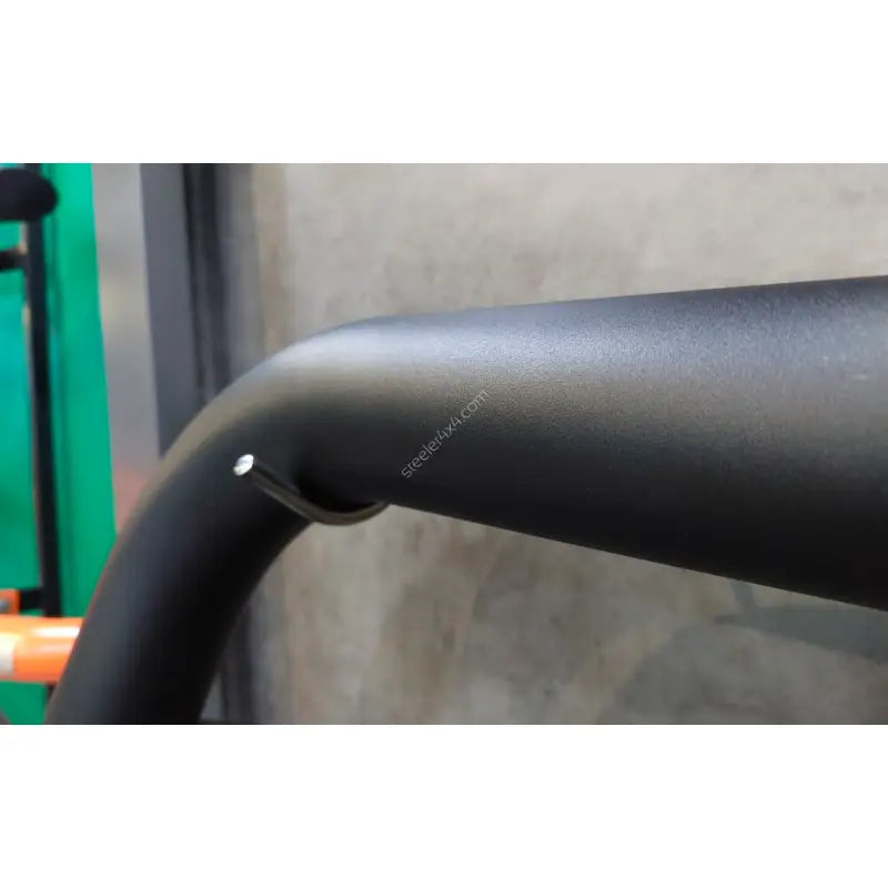 Kufanger til Chevrolet Captiva 12-15 i matt svart metall, nærbilde fra siden med krok, betongvegg bak.