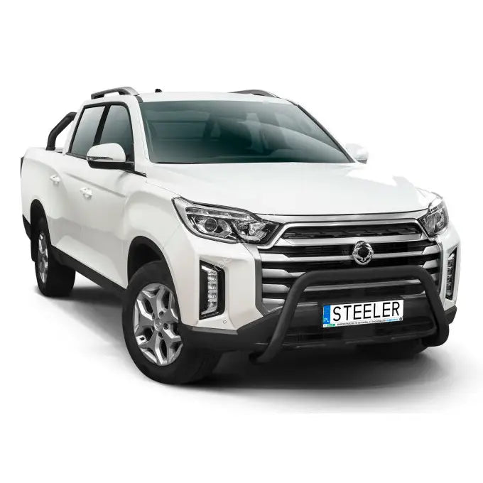 Kufanger på hvit SsangYong Musso 21-modell med sorte detaljer og aluminiumsfelger, sett skrått forfra.