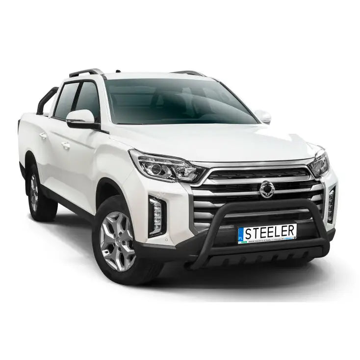 Kufanger på hvit SsangYong Musso pickup med store lykter, takrails og aluminiumsfelger, sett forfra.