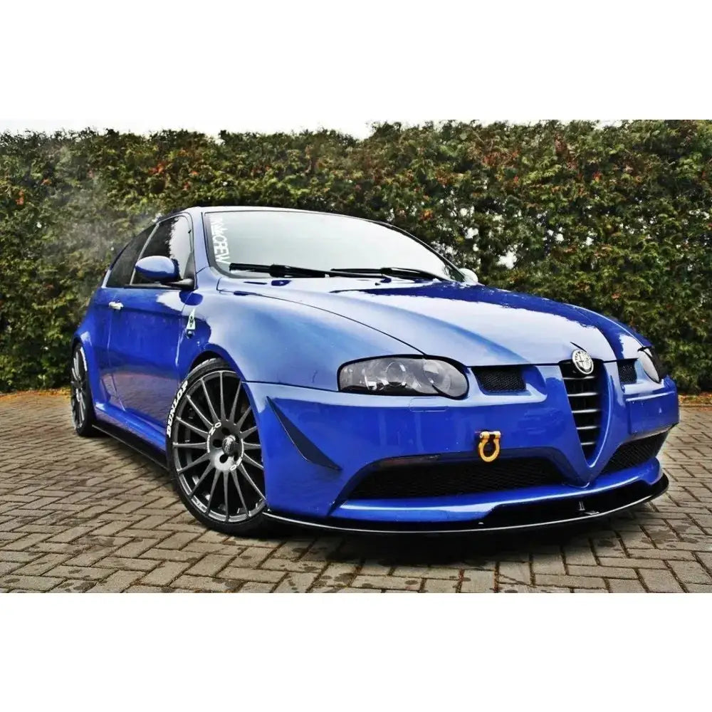 Spoiler på Alfa Romeo 147 Gta, blå sportsbil med svarte felger og gul tauekrok foran.