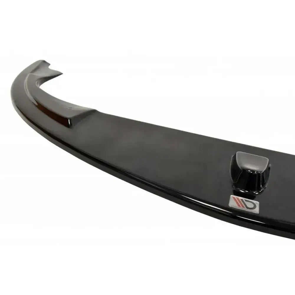 Frontspoiler Alfa Romeo 147 Gta i svart blank plast, nærbilde av aerodynamisk leppe med logo og formdetalj.