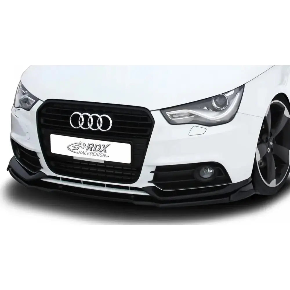 Frontspoiler Audi A1 8X/8XA 11-15 Sportback i sort på hvit bil sett forfra, nærbilde med grill og tåkelys.