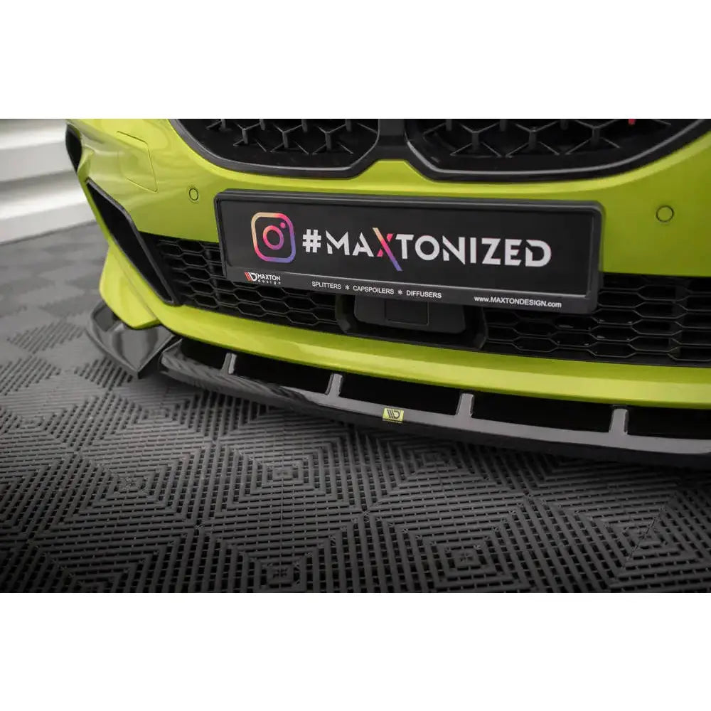 Front splitter på sort plastspoiler montert på lys grønn BMW 1 Serie F40 med Maxtonized-skilt.