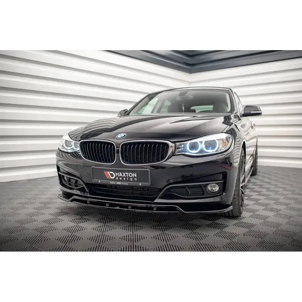 Front splitter på BMW 3 GT F34 13-16, sort frontspoiler og LED-frontlykter i lyst rom.