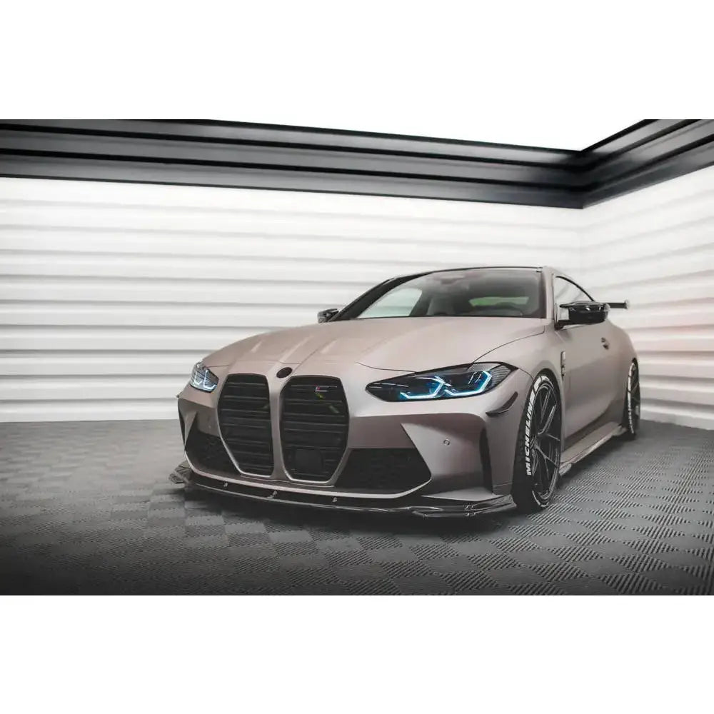 Spoiler til BMW M4 G82 V.2 karbon montert på matt grå bil med sorte detaljer og blå frontlykter.