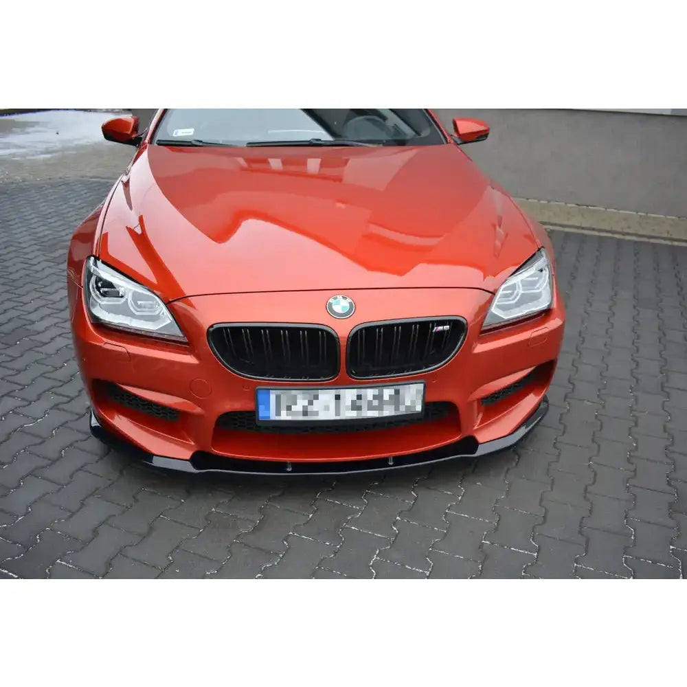 Frontspoiler BMW M6 Gran Coupé i rødt sett forfra med sort grill og lave frontlykter på asfalt.
