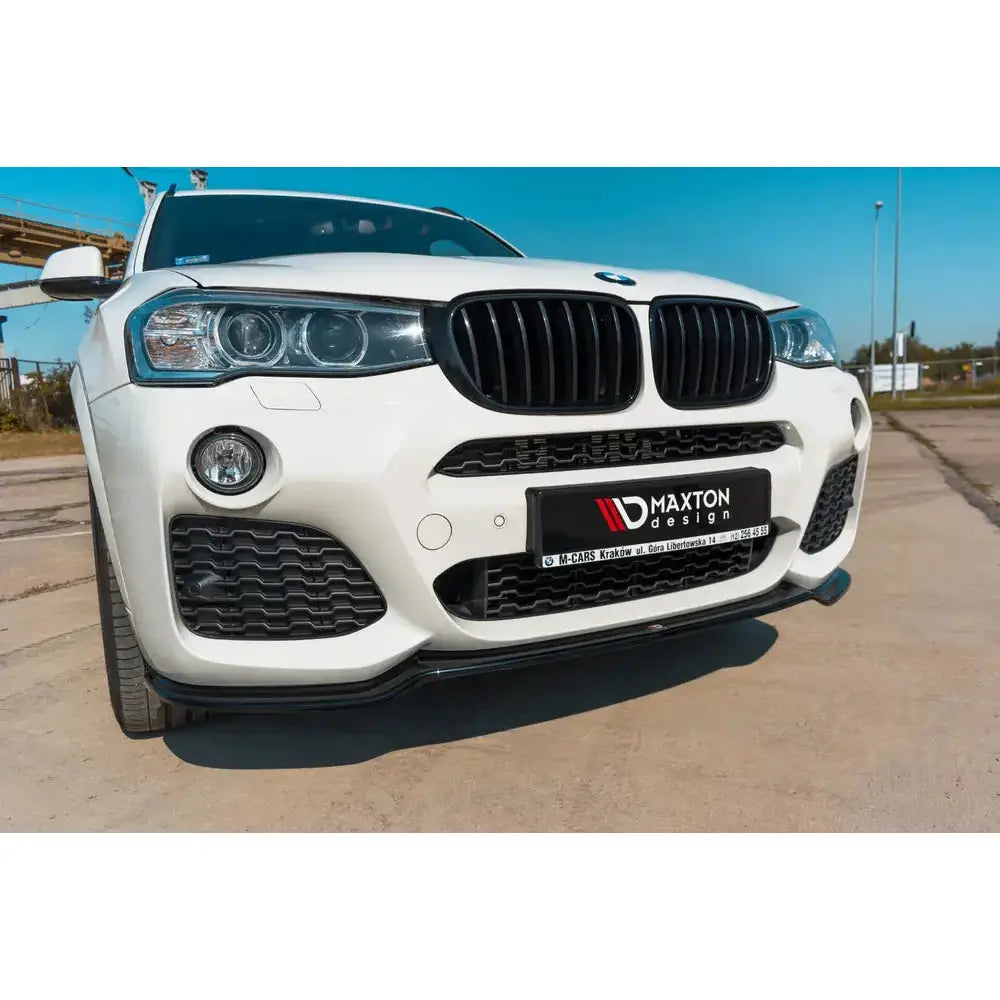 Spoiler på BMW X3 F25 M-Pack Facelift, sort spoiler under frontfanger med tydelige lykter og grill.