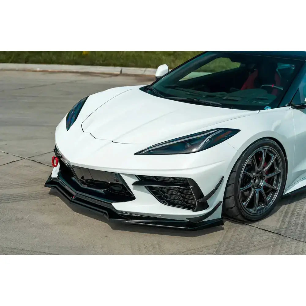 Spoiler til Chevrolet Corvette C8 med sorte detaljer og rød tauekrok, sett fra venstre front.