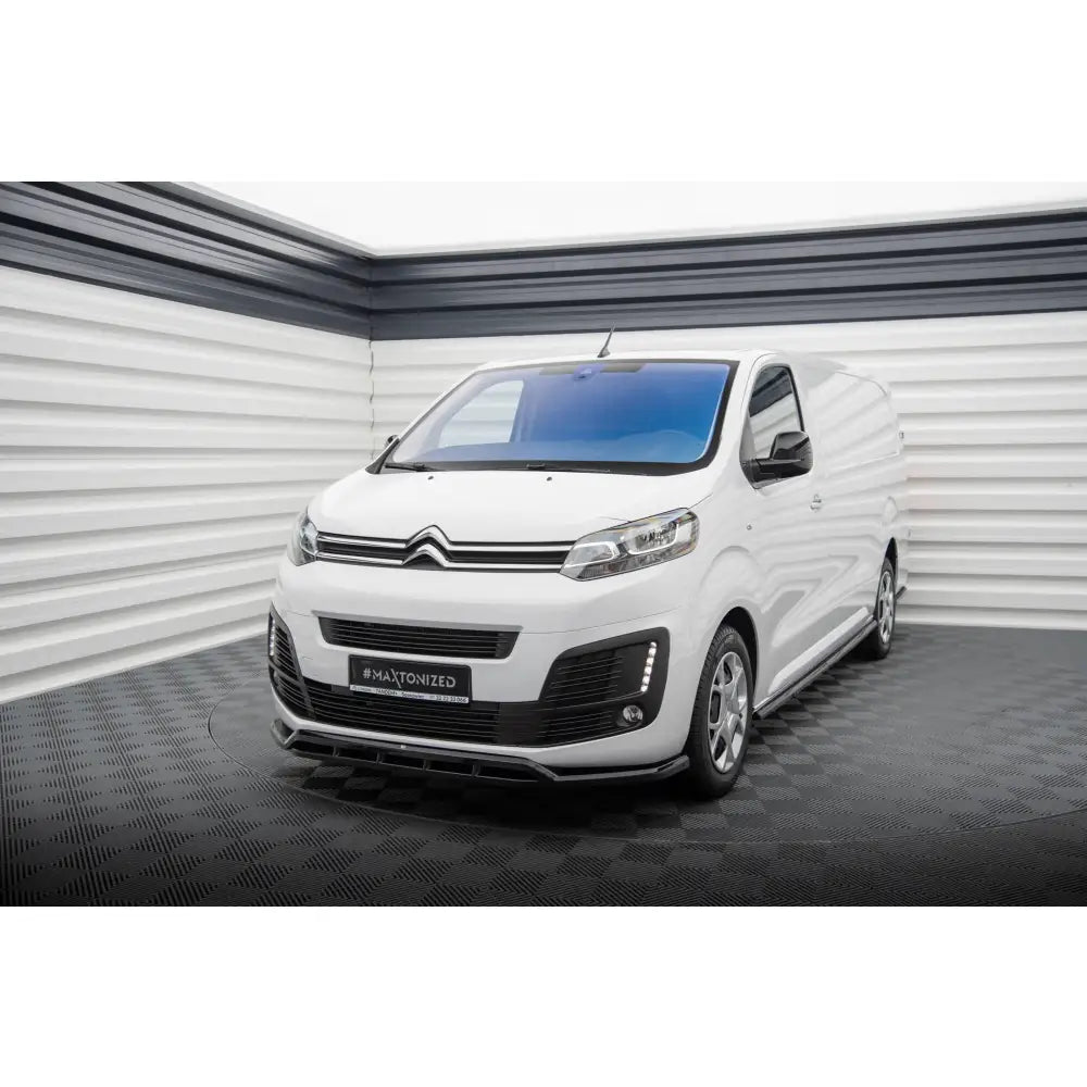 Frontleppe på hvit Citroen Jumpy Mk3 varebil med svart grill, fotografert i lyst studio med rutegulv.