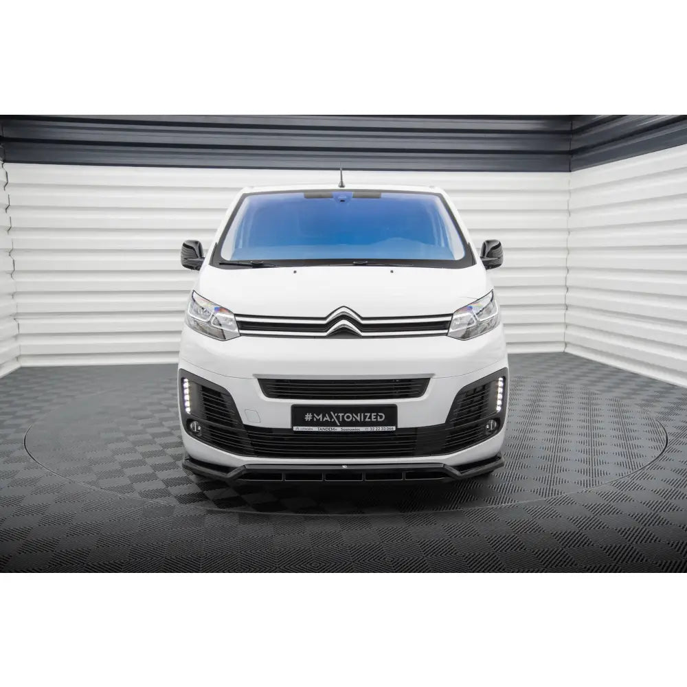 Frontspoiler på Citroen Jumpy Mk3 sett forfra med svart grill og LED-lys mot lyst bakteppe.