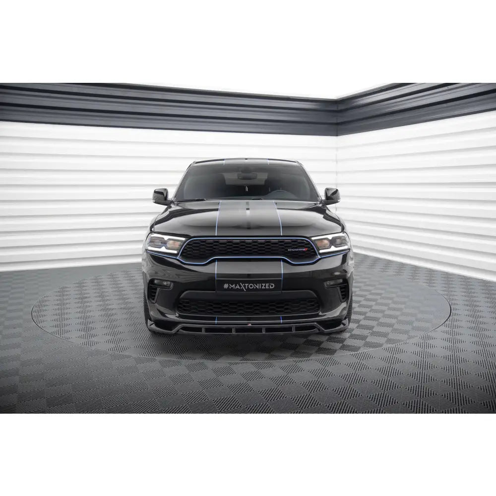 Frontleppe på Dodge Durango Mk3 Facelift SUV med blå dekorlinjer, sett forfra i lyst fotostudio.