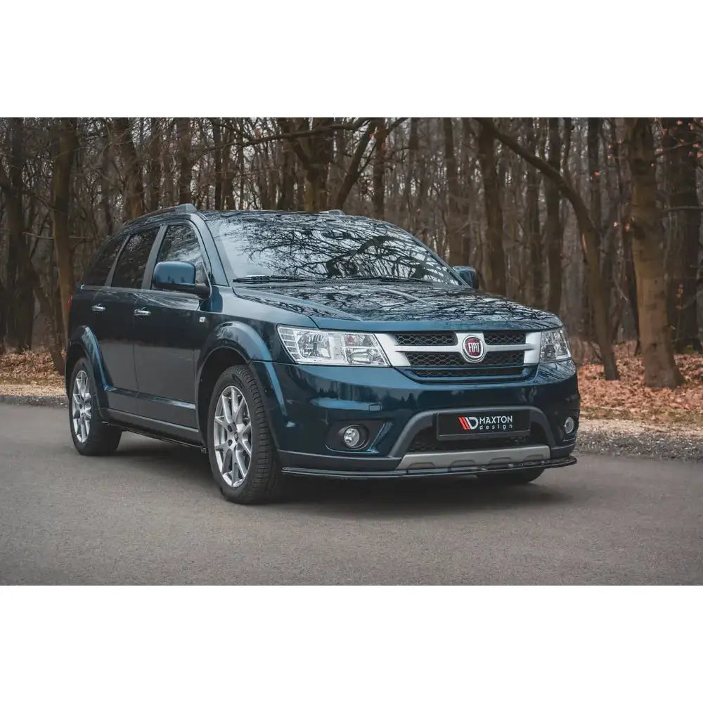 Frontleppe på Fiat Freemont svart SUV med aluminiumsfelger og kromdetaljer parkert på asfaltvei.