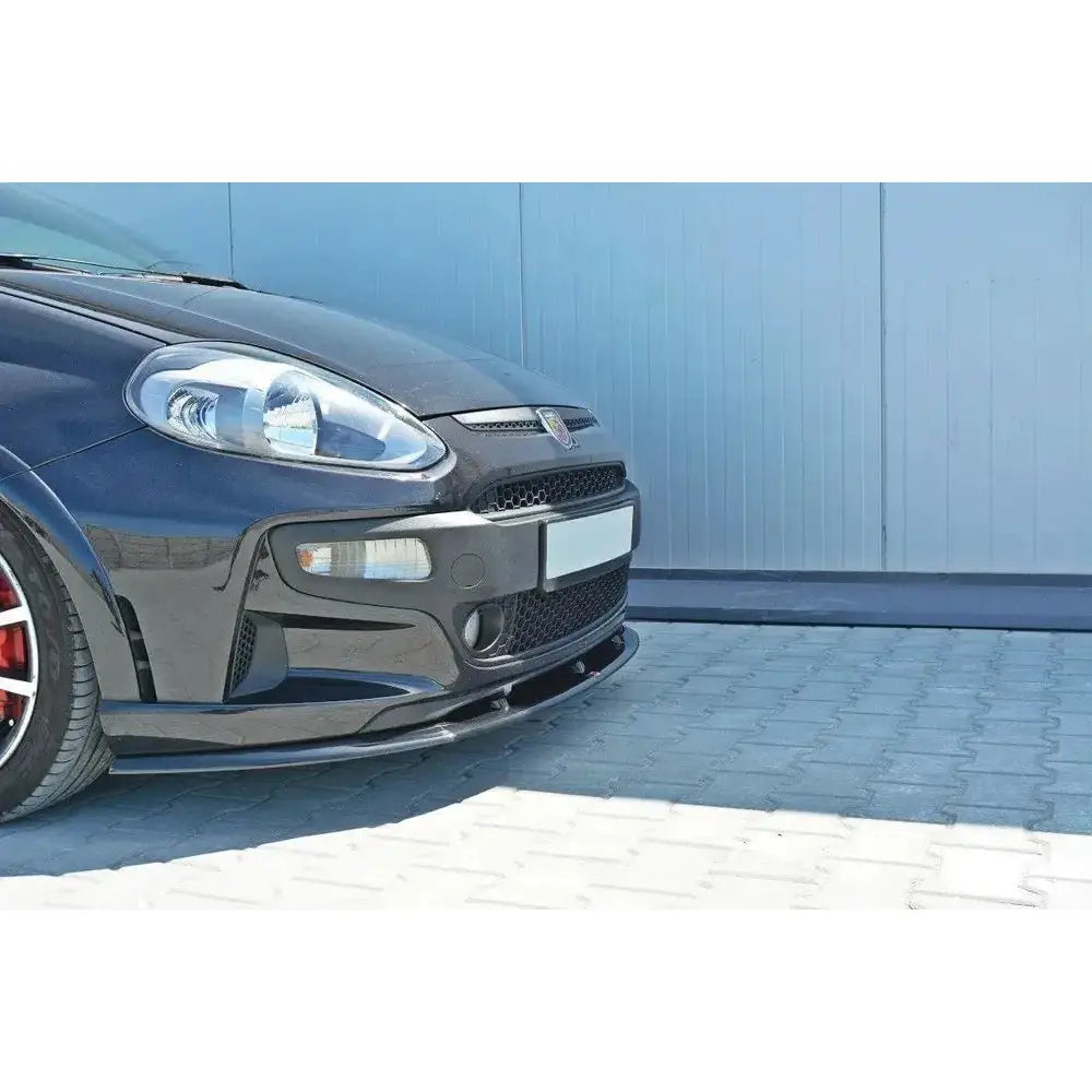 Front lip på Fiat Punto EVO Abarth, nærbilde av sort frontspoiler med lykter og sportsfelg.