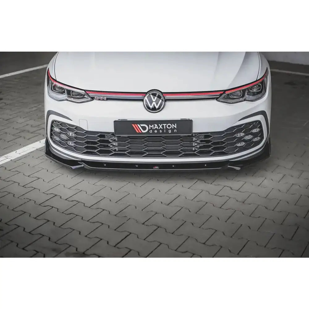 Frontleppe på Volkswagen Golf 8 GTI med sort og rød grill, sett rett forfra og nedenfra.