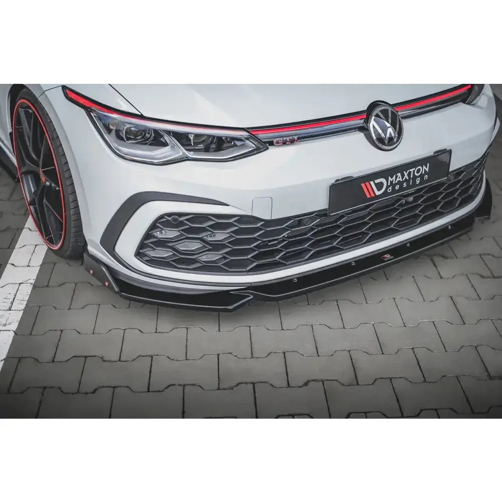 Front splitter på Volkswagen Golf 8 GTI med sort og rød detalj, luftinntak og sekskantet grill.