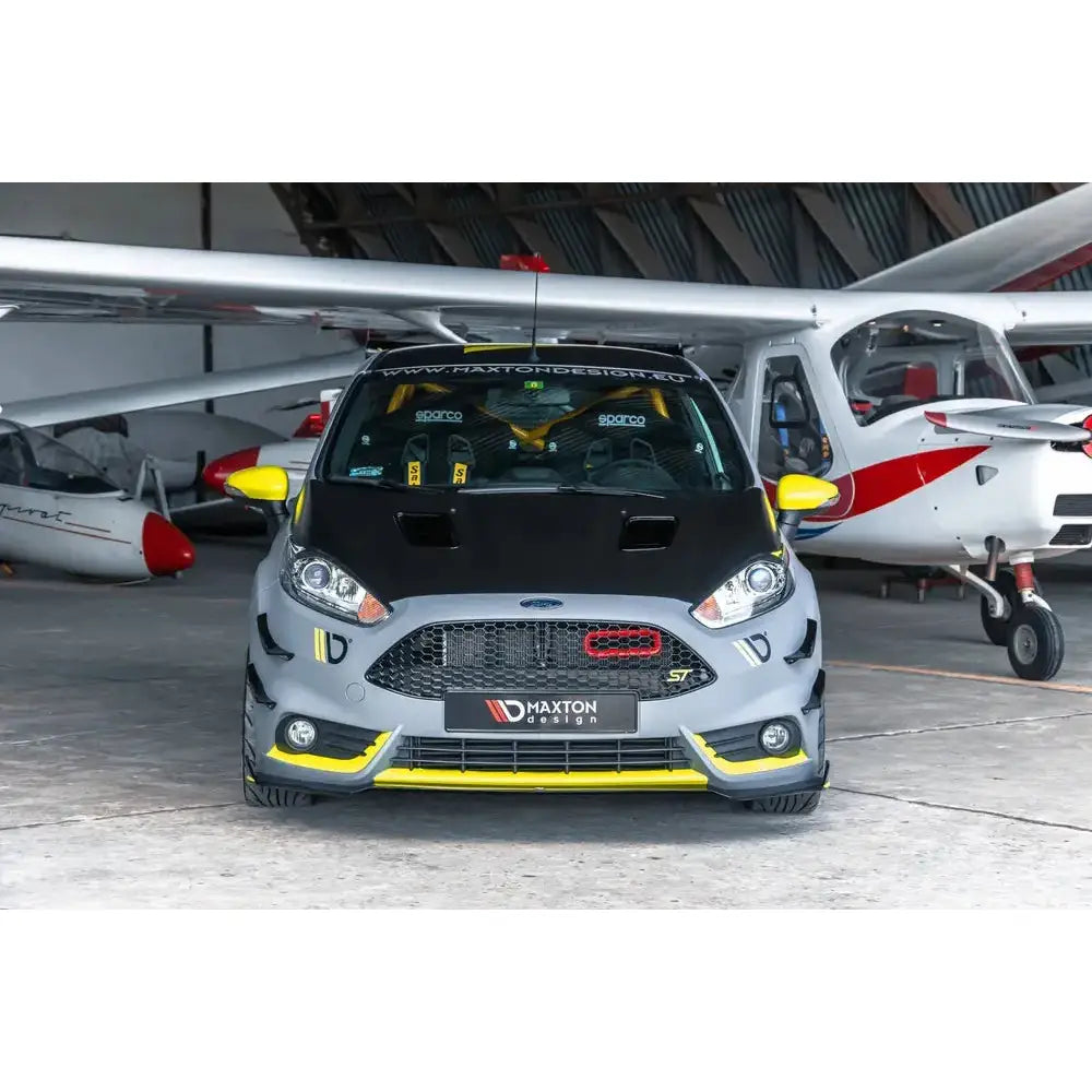 Front lip på Ford Fiesta 7 ST Facelift, grå sportsbil med gul og svart detaljer foran småfly.
