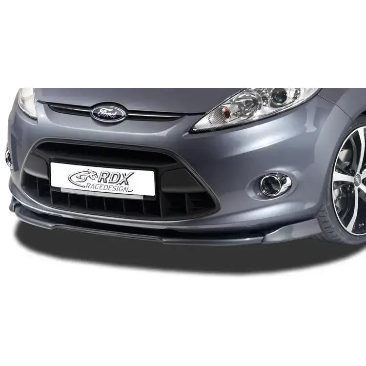 Frontspoiler Ford Fiesta MK7 JA8 JR8 08-12 i sort plast, montert på grå bil med moderne lykter.