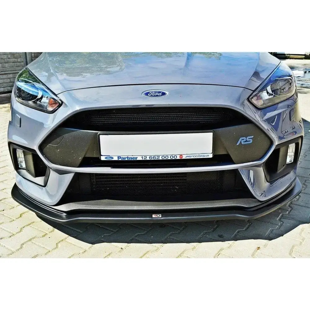 Frontleppe på Ford Focus 3 RS V.4 med sort grill og RS-emblem, parkert på steinbelagt underlag.