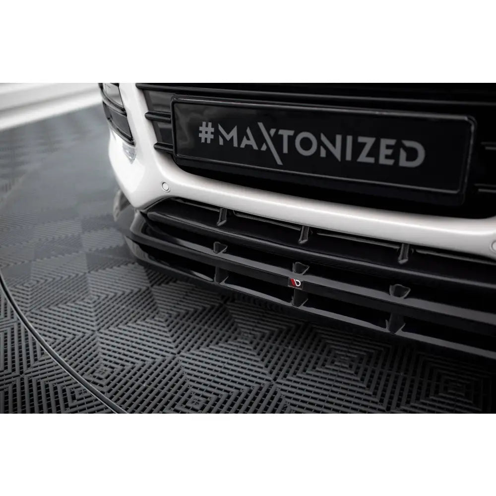 Front lip på Ford Kuga ST-Line Mk2 med svart grill og hvit støtfanger, nærbilde fra lav vinkel.