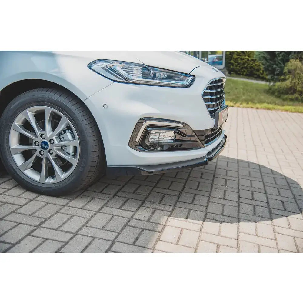 Front lip på Ford Mondeo MK5 Facelift, nærbilde av venstre hovedlykt, grill og felg mot steinlagt underlag.