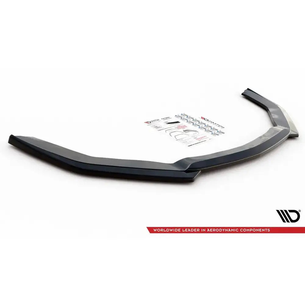 Front lip til Ford Mustang MK. 6 Facelift, sort plast med monteringsskruer og bruksanvisning i bakgrunnen.