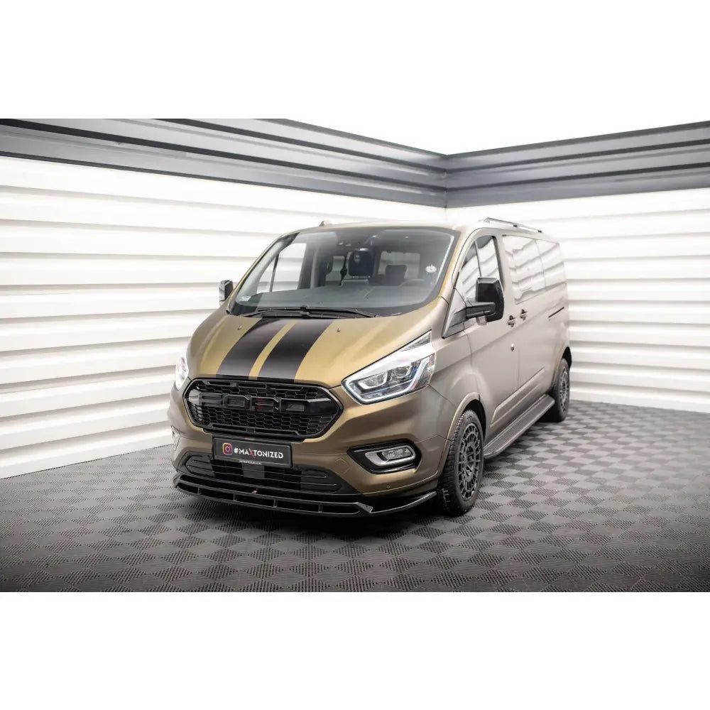 Frontleppe på bronsefarget Ford Tourneo Custom Mk1 Facelift med sorte striper og detaljer, innendørs.