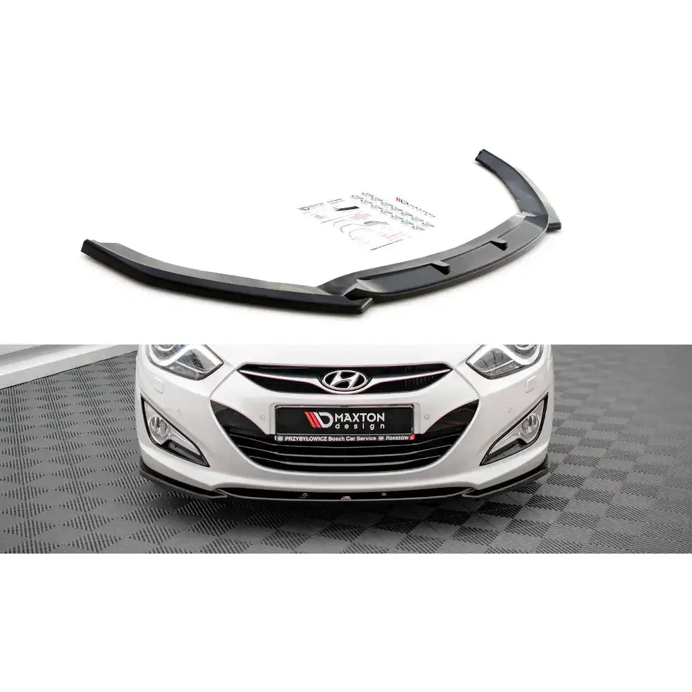 Frontspoiler Hyundai I40 Mk1 11-13 i sort plast sett skrått og montert på hvit bilfanger med detaljer.