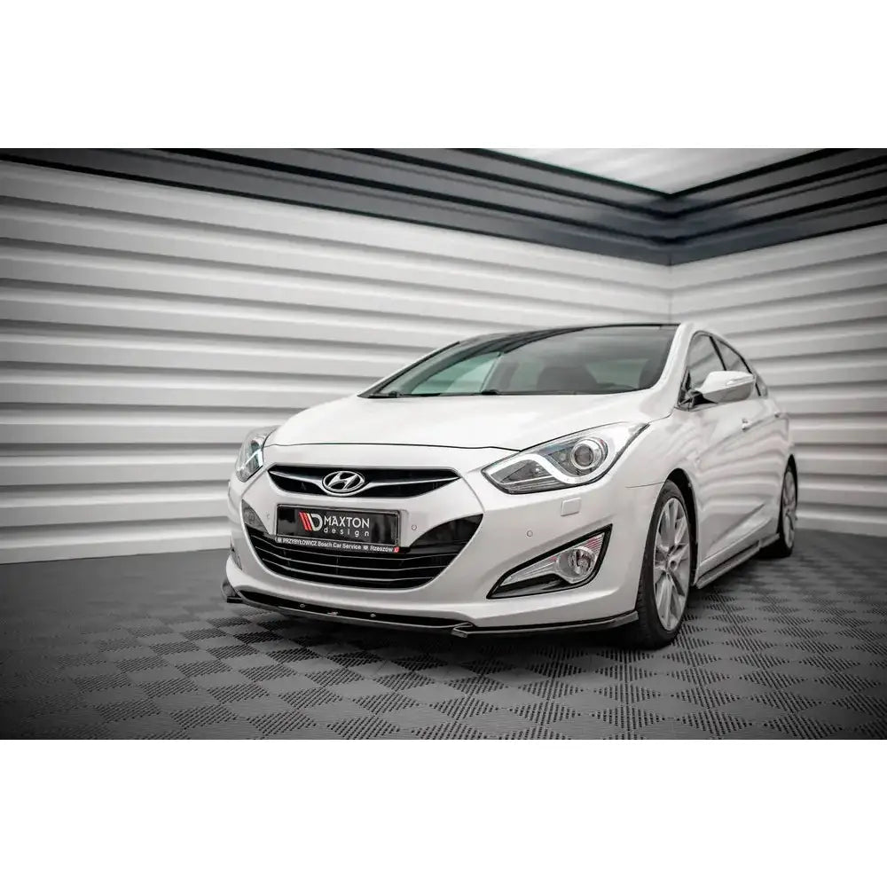 Front splitter på hvit Hyundai I40 Mk1 11-13 med svarte detaljer i lyst rom.