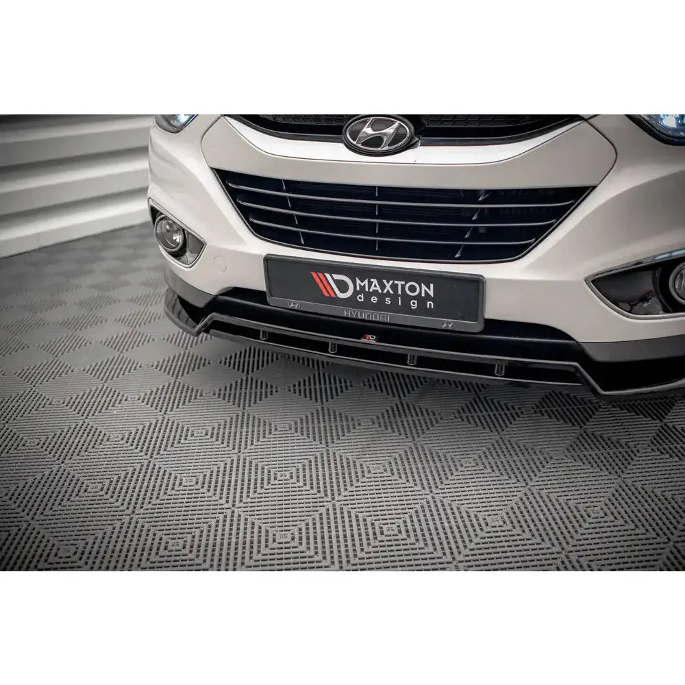 Spoiler til Hyundai ix35 Mk1 09-13 montert på hvit bil med svart splitter og detaljert grill.