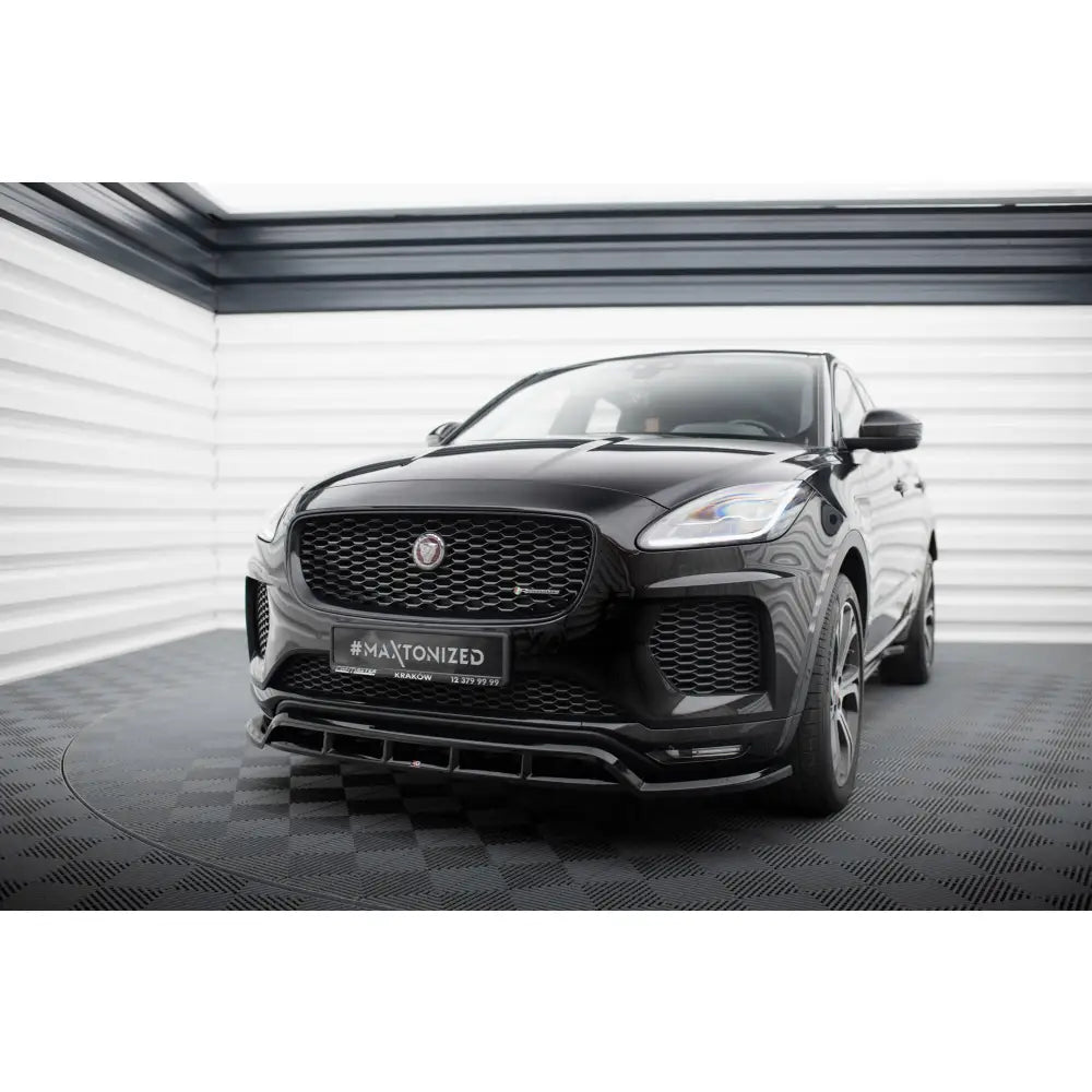 Frontleppe på Jaguar E-Pace R-Dynamic Mk1, svart SUV med blank grill og sportslig design i lyst studio.