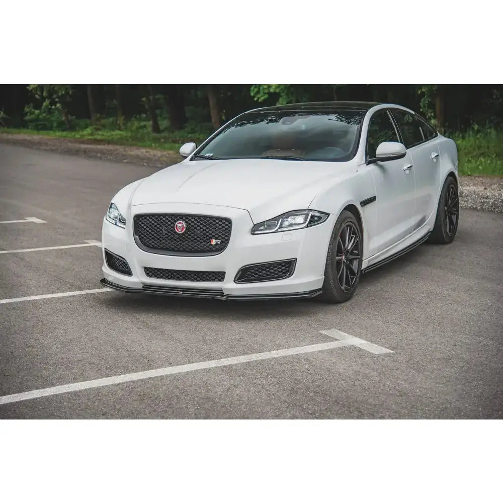 Spoiler på Jaguar XJ X351 Facelift, hvit sedan med svart panser og mørke felger parkert ute.