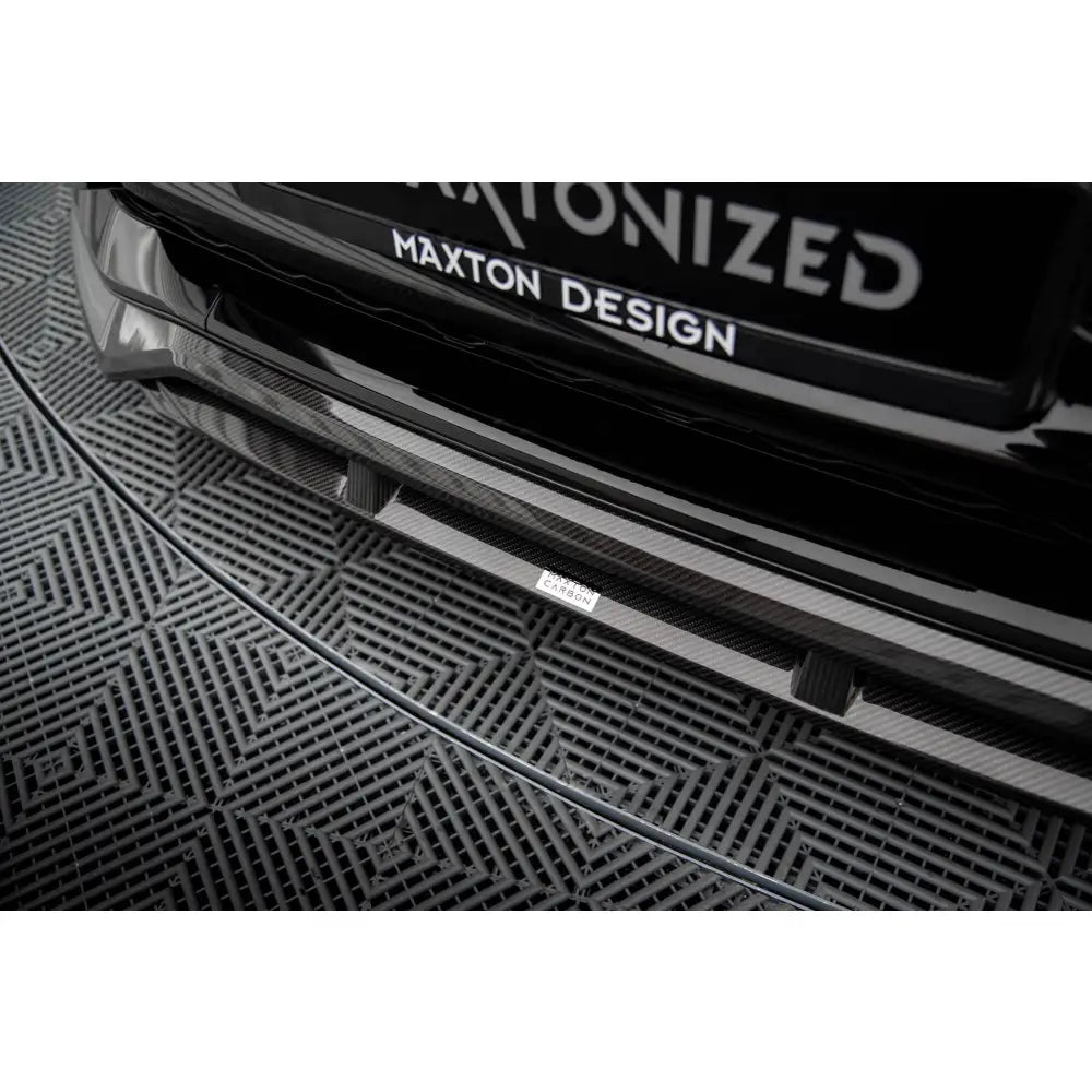 Spoiler Audi RSQ8 Mk1 i sort karbonfiber sett ovenfra, nærbilde med Maxton Design-logo og synlig karbonmønster.