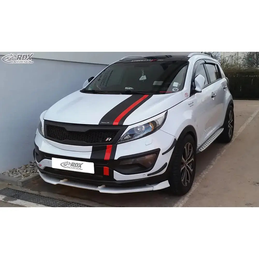 Front splitter på hvit Kia Sportage SL 10-15 med sorte og røde striper, sporty detaljer og svarte felger.